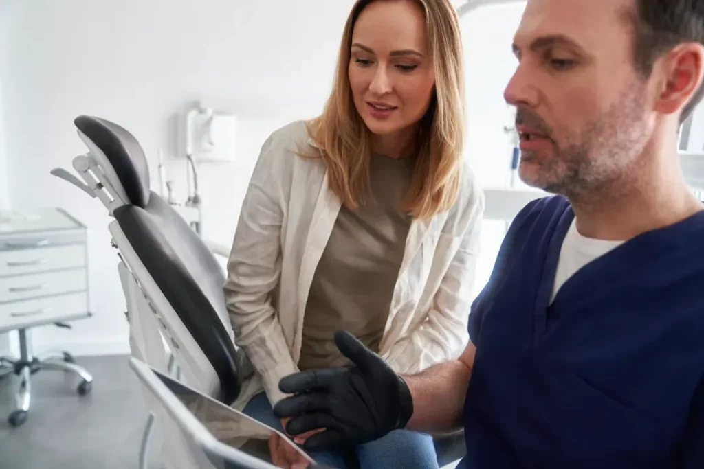 A dental team member reviewing treatment images with a patient